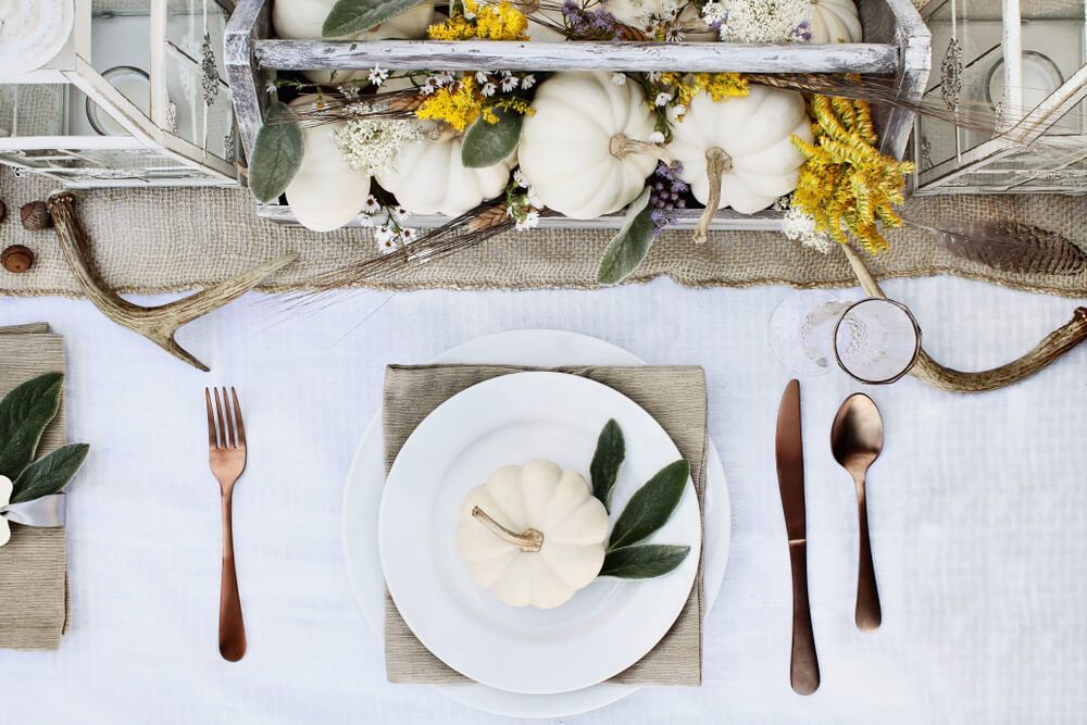 white themed table setting with bronze cutlery